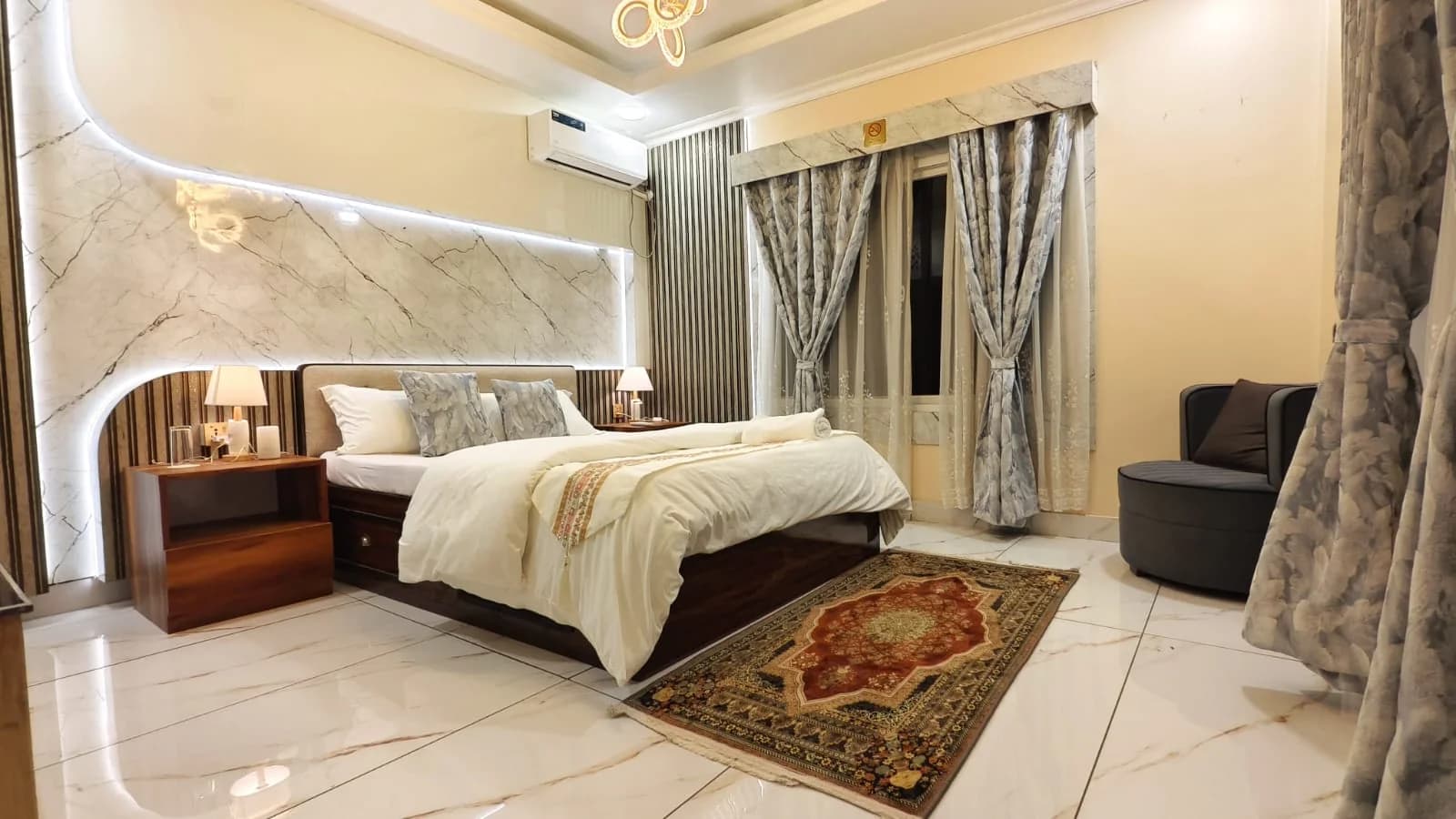 Bedroom one with marble accent wall and rug