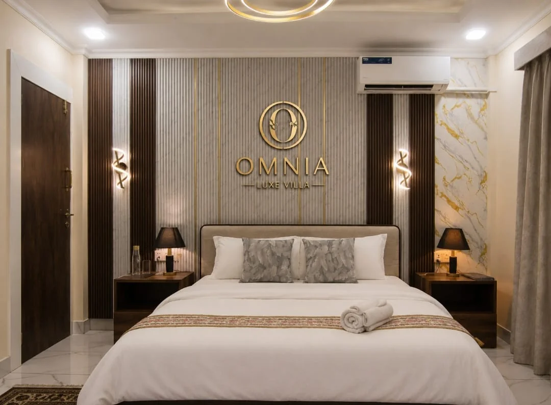 Bedroom one at Omnia Luxe Villa,queen bed with marble accent wall and ambient lighting