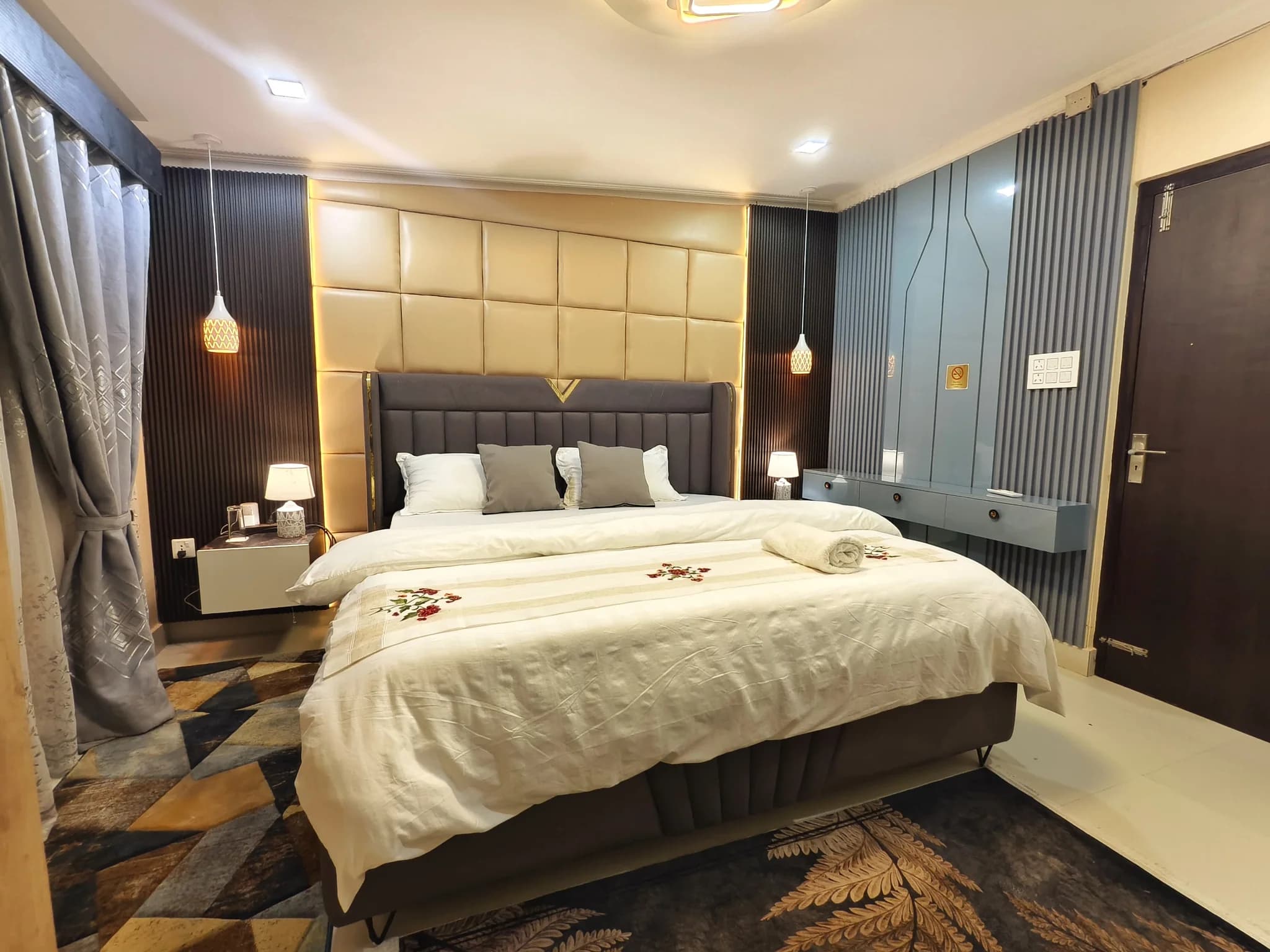 Bedroom with padded headboard and blue accent wall