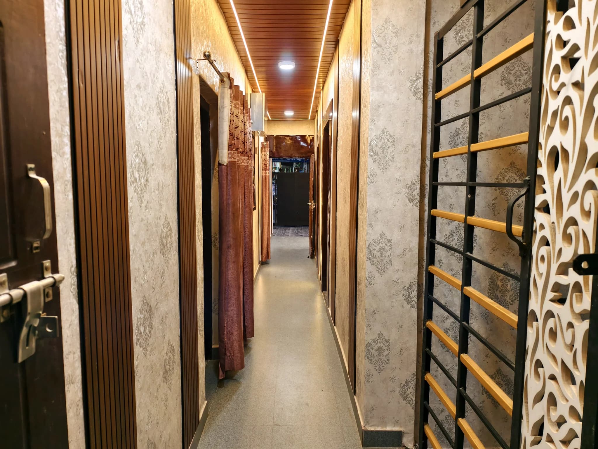 Corridor with wood-slat ceiling and wallpaper