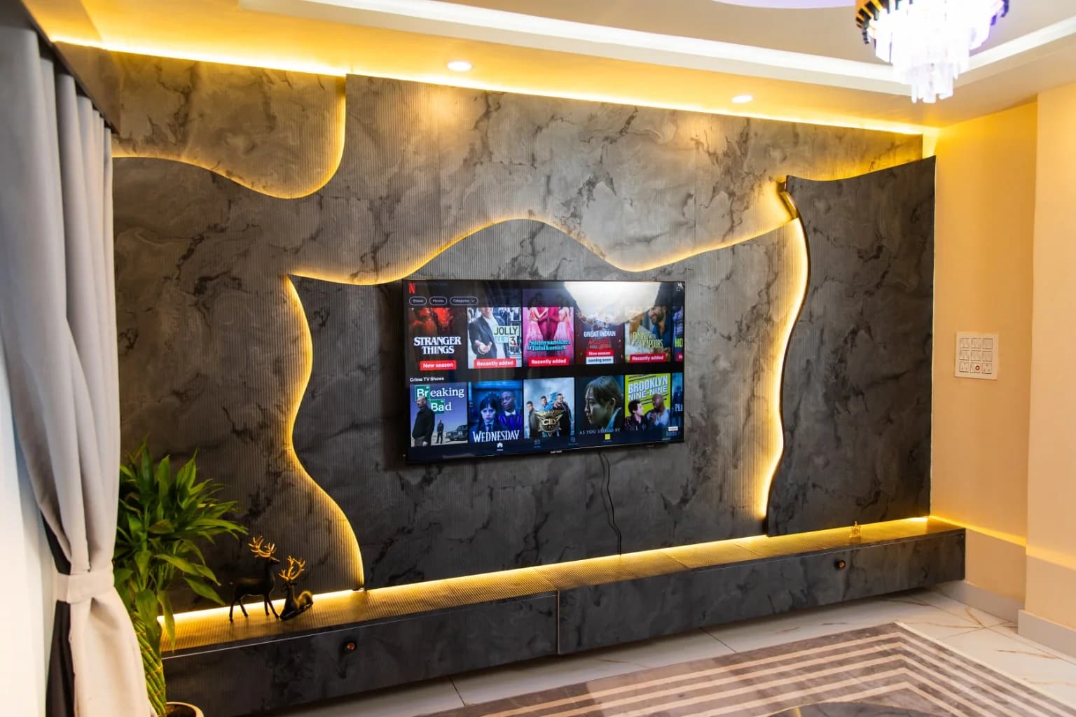 Backlit sculpted stone media wall with television